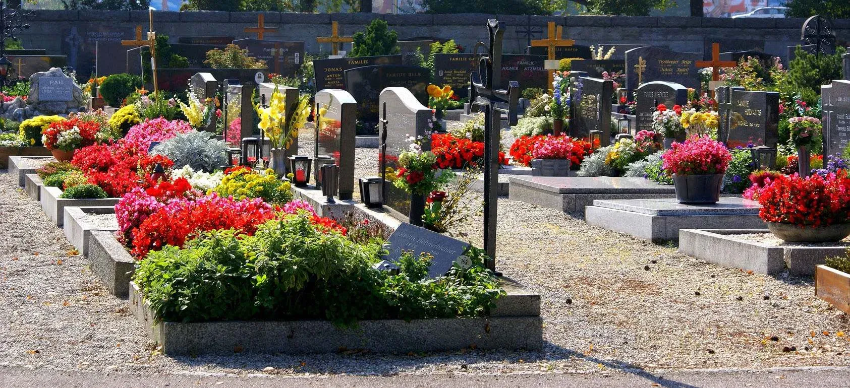 Tombes ornées de compositions florales colorées dans un cimetière.