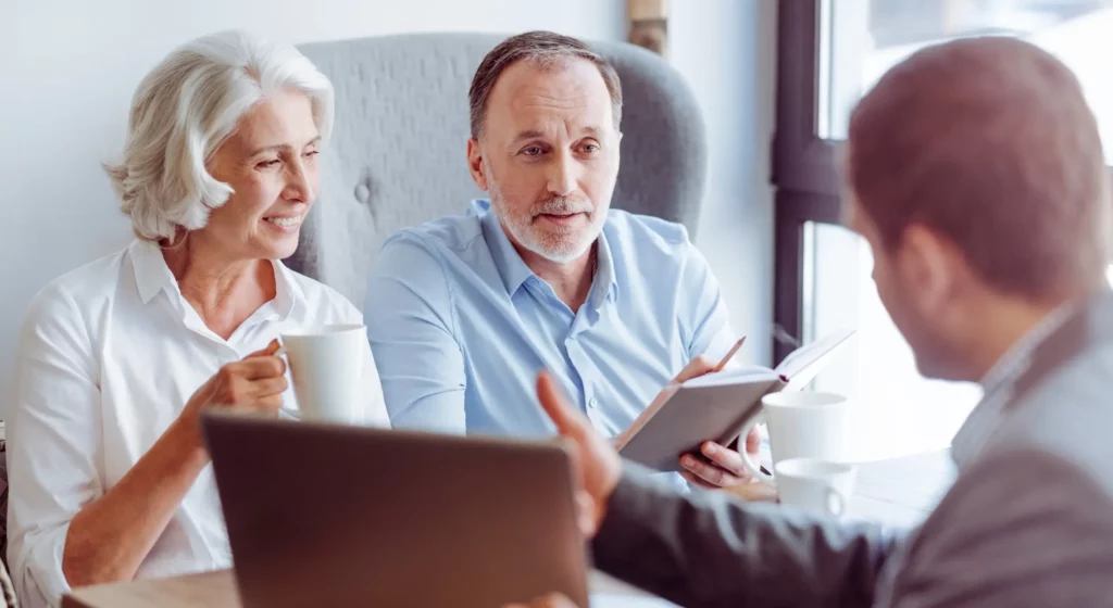 Couple senior en entretien de prévoyance obsèques avec un conseiller.